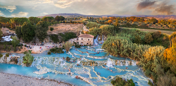 Most famous natural thermal hot spings pools in Tuscany - scenic Terme di Mulino vecchio ( Thermals of Old Windmill) in Grosseto province. high angle drone shoot