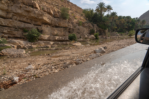 Cars driving on flooded road after heavy rain to oasis Wadi Bani Khalid.  Oman
