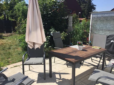 Garden table with parasol and chairs