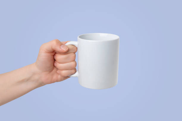 istock White cup held with surface for logo mockup promotion. Purple background 2046277489