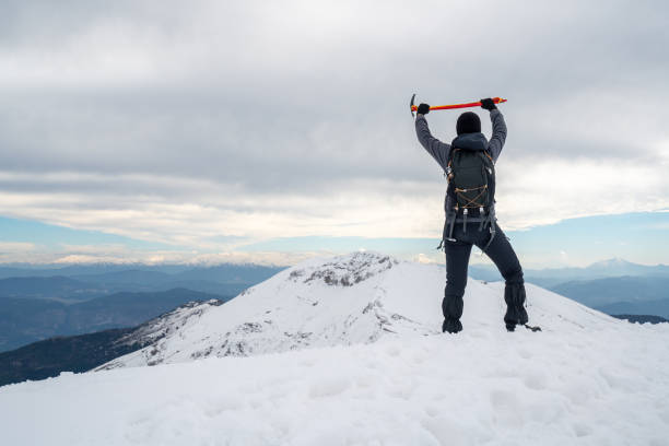 Alpinist climber is proud  and happy for being on the summit of a mountain