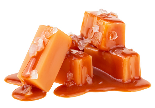 Delicious candies with caramel sauce and sea salt isolated on a white background