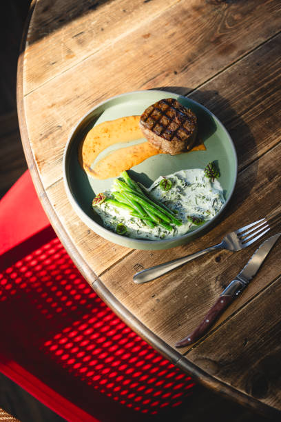 Barbecued turkey breasts steaks ready to eat, served at plate with glazed carrots and white mushrooms,