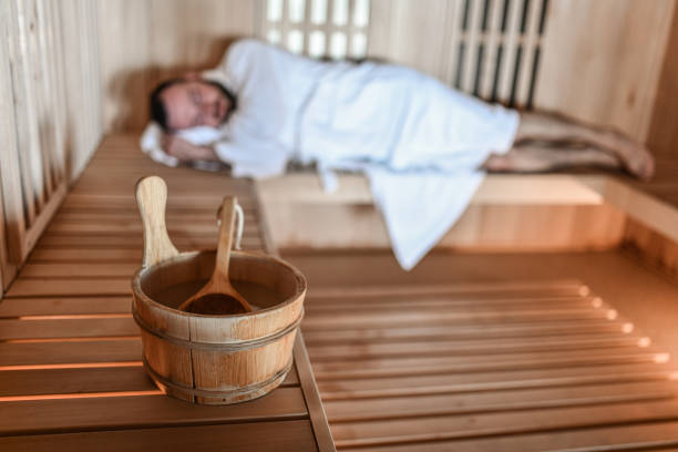 Bucket Full Of Water Placed On Sauna Boards While Male Is Sleeping