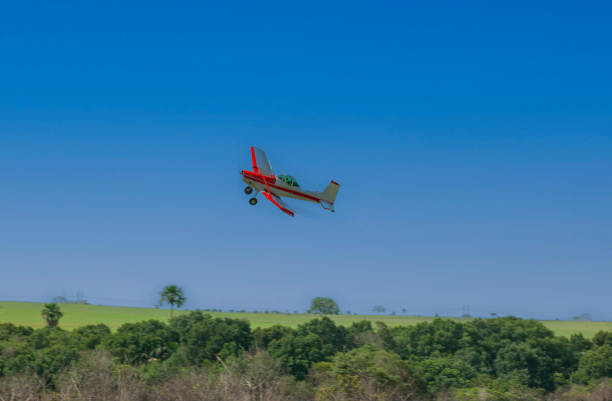 Bogota, Colombia ., 15 de Junio 2004: Model airplane flies in the blue sky over a green field