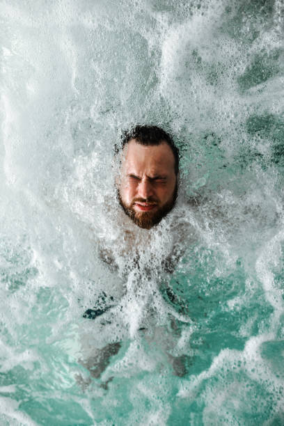istock Male Floating Peacefully In Foamy Pool Water 2046329751