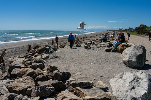 Hokitika, Nieuw-Zeeland – 17 februari , 2023: Uitzicht over het strand van kuststadje Hokitika op het zuidereiland van Nieuw-Zeeland, met stenen en aangespoeld wrakhout