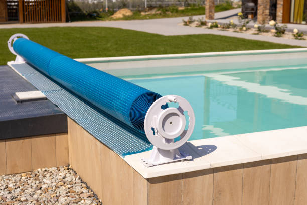 Swimming pool cover for protection against dirt, leaves, heating and cooling water, copy space. Blue tarpaulin pool cover. Summer day Swimming pool cover for protection against dirt, leaves, heating and cooling water, copy space. Blue tarpaulin pool cover. covering stock pictures, royalty-free photos & images