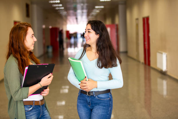 istock Happy young university students standing in corridor during break 2046381583