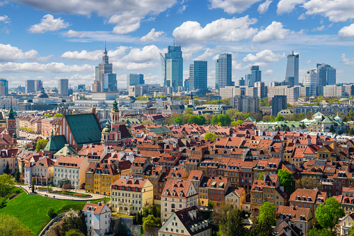 Warsaw old town and distant city center, PKiN and skyline under blue cloudy sky aerial landscape