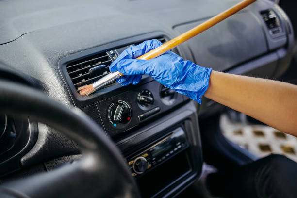 istock Young woman cleaning car interior using brush 2046494377