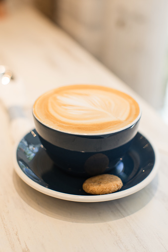 Close-up view of a hot latte with a crispy cookie on the side in a local coffee shop in sunny Miami Beach, Florida in February of 2024.