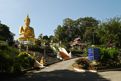 Phra Phut Tha Maha Phratimakhon It is a large golden Buddha image sitting outdoors on a hill. Inside Wat Phra That Doi Saket. This temple is another important one in the ์์Northern part of Thailand.