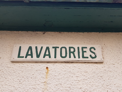 Lavatories sign on a white painted metal plate on a white painted wood, Largs, Glasgow Scotland England