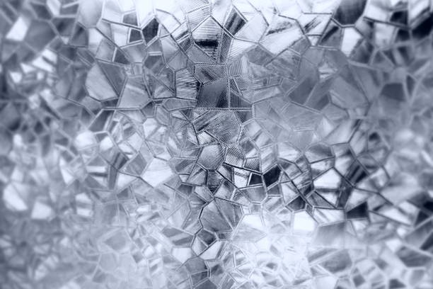 Embossed glass background. Corrugated glass monochrome. Refraction of light in a bumpy transparent surface under backlight. The play of white and gray highlights. Black areas. Abstract background.