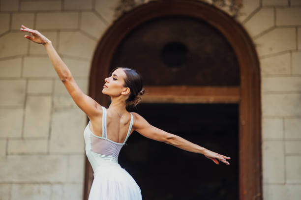 Elegant movements and gracious choreography of prima ballerina at ghosted and abandoned place. A ballet dancer is performing her art in ruined place. Art of ballet dance and ruined exterior.