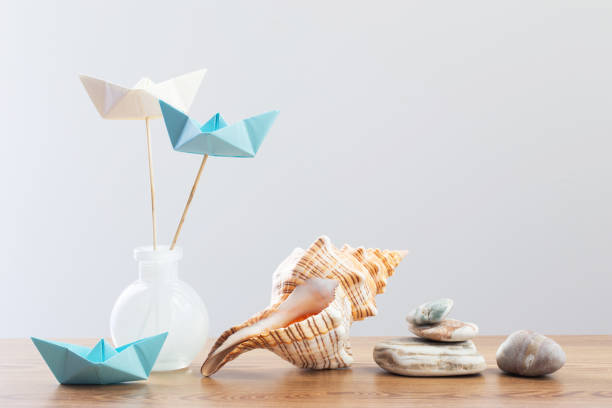 paper boats in glass vase with sea decor on wooden table - nautical vessel isolated toy boat wood photos et images de collection