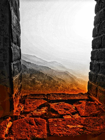 Sunrise view through window of wall at the top of the mountains
