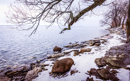 The rock and snow covered shore of The St Lawrence River.