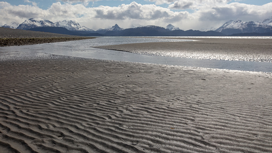 Tidal mud flats under cloudy skies on Homer Spit in Homer Alaska United States