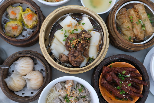 Assorted dim sum and other steamed Chinese food in bamboo steamers, a feast for Chinese cuisine-themed content and food photography
