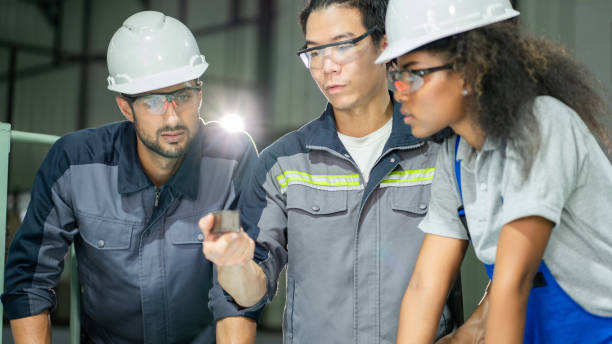 Multiracial Engineers Collaborate for Metal Parts Project in Factory Workshop.