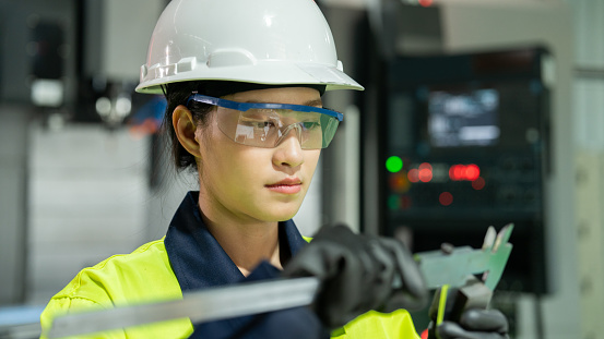 Experience the mastery of our Asian specialist as she employs a Vernier caliper for meticulous quality control, guaranteeing precision and excellence in every metal component.