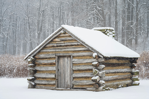 Log cabin covered with snow at Valley Forge National Historic Park, King of Prussia, Pennsylvania, USA