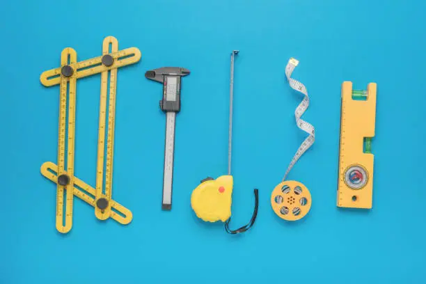 A large set of various measuring instruments on a blue background. A tool for accurate measurement of dimensions.