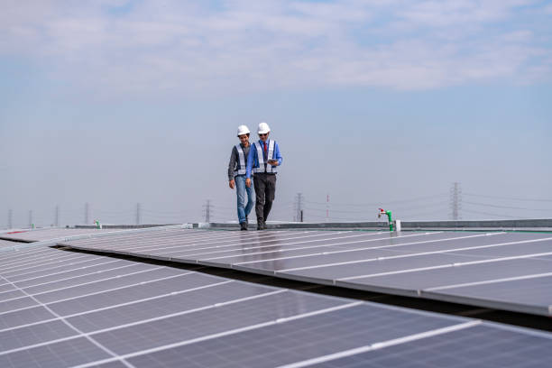 istock Engineers walking on roof inspect and check solar cell panel by hold equipment box and radio communication ,solar cell is smart grid ecology energy sunlight alternative power factory concept. 2046873985
