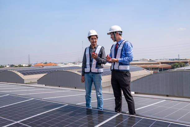 istock Engineers walking on roof inspect and check solar cell panel by hold equipment box and radio communication ,solar cell is smart grid ecology energy sunlight alternative power factory concept. 2046874066