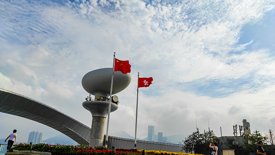Hong Kong, February 18,2024 : Kai tak Cruise terminal park, Chinese and Hong Kong flags with sky background.