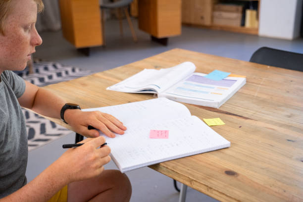 istock School boy goes through the notes his teacher made in his workbook 2046907659