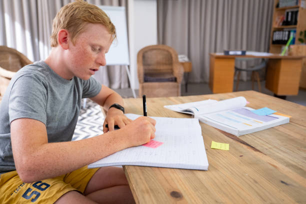 istock School boy goes through the notes his teacher made in his workbook 2046908163