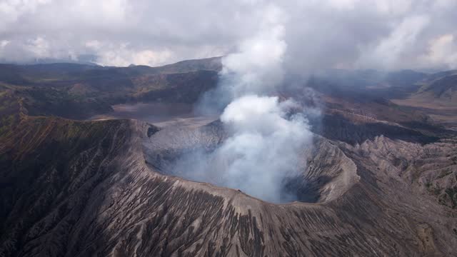 Bromo Crater: A surreal marvel in East Java, Indonesia. Witness wisps of smoke and bursts of volcanic activity, stunning vistas in this iconic volcanic caldera, aerial 4k drone footage