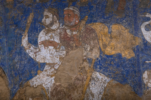 26 June, 2023, Samarkand, Uzbekistan: Central Asian fresco of the 7th-8th centuries from the Ishhid palace. Depicted are court warriors or nobles with swords. Afrasiab Museum, Samarkand, Uzbekistan