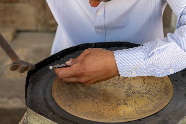 JUNE 27, 2023, BUKHARA, UZBEKISTAN: The master doing the metal work to sell it as a souvenir