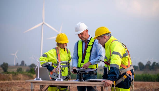 istock Engineer surveyor and manager wearing uniform walking holding box inspection and tablet work in wind turbine farms rotation to electricity, alternative renewable energy for clean power energy concept. 2046928662