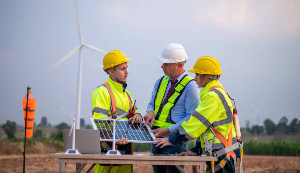 istock Engineer surveyor and manager wearing uniform walking holding box inspection and tablet work in wind turbine farms rotation to electricity, alternative renewable energy for clean power energy concept. 2046929180