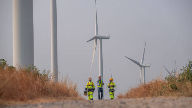 istock Engineer wearing uniform ,helmet hold document inspection work in wind turbine farms rotation to generate electricity energy. Green ecological power energy generation wind sustainable energy concept. 2046933474