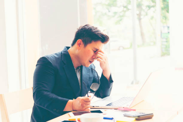 istock Asian man feeling tired suffering using computer working work place.concept global economic,health problems 2046947750