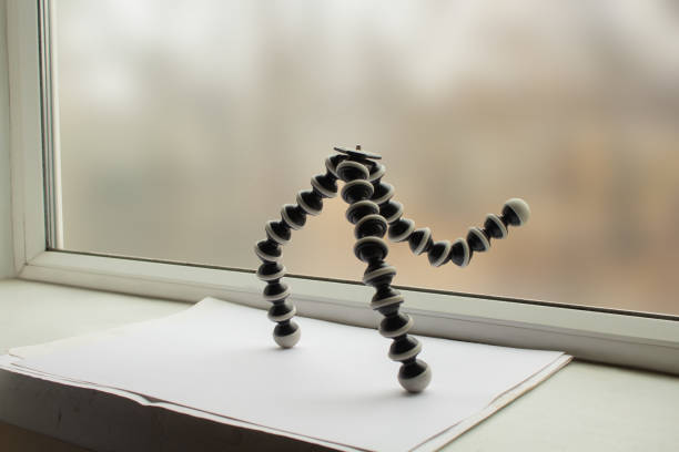 Brand new, small tripod for camera and smartphone standing on the windowsill