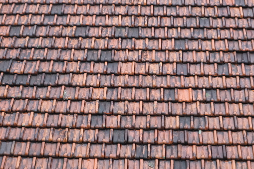 Texture of wet terracotta tiles roof background after raining, ideal for architecture and construction content.