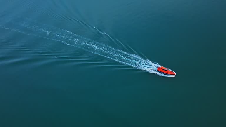 AERIAL Drone Shot of Small Boat Sailing and Creating Wake on Sea