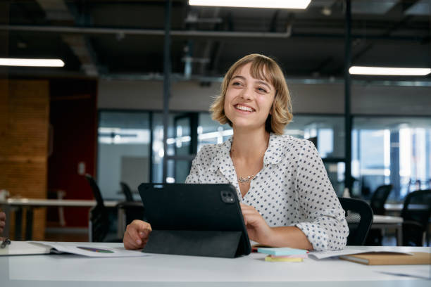 istock Two multiracial business people smiling while using digital tablet during meeting in office 2047015507