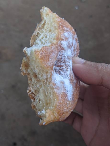 istock Portrait of hand holding donut with powdered sugar 2047020911