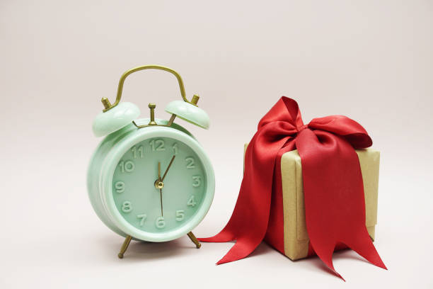 istock Gift box with red ribbon and Alarm clock on pink background 2047021414