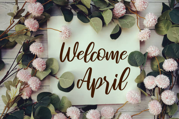 istock Welcome April text message with flower decoration on wooden background 2047021919