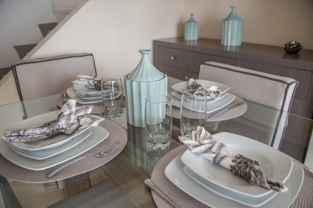 A beautifully set table adorned with plates, bowls, various utensils, and a decorative plant placed elegantly on it, creating a delightful dining atmosphere and inviting mealtime experience