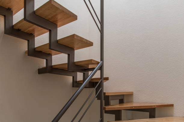 istock Spiral wooden staircase with a black railing, beautiful lighting. 2047040846